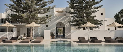 Una piscina al aire libre de temporada, sombrillas