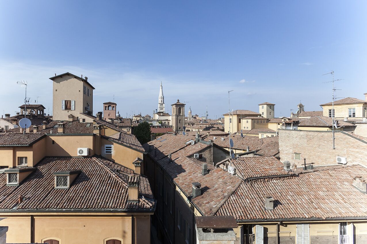 A cityscape with traditional architecture, including buildings with tiled roofs and a prominent tower.