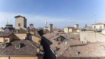 A cityscape with traditional architecture, including buildings with tiled roofs and a prominent tower.