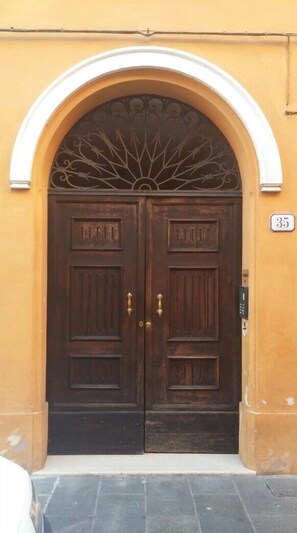 Double doors with brass handles and a decorative grille.