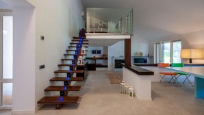 Un intérieur moderne avec un escalier en bois, un coin repas et une cuisine.