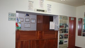 A reception desk with a sign reading "RECEPCIÓN" and a "HOTEL CASA REAL" poster. - Hotel Casa Real (Quetzaltenango)