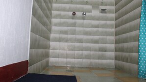 A small, tiled shower room with a blue curtain and a red baseboard. - Hotel Casa Real (Quetzaltenango)