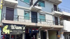 A multi-story building with a ground-floor shop named 'Wam's' selling clothes and accessories. - Hotel Casa Real (Quetzaltenango)
