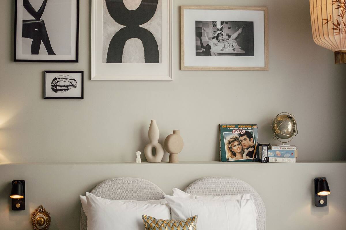 A neatly arranged bedroom with a bed, pillows, and wall art.