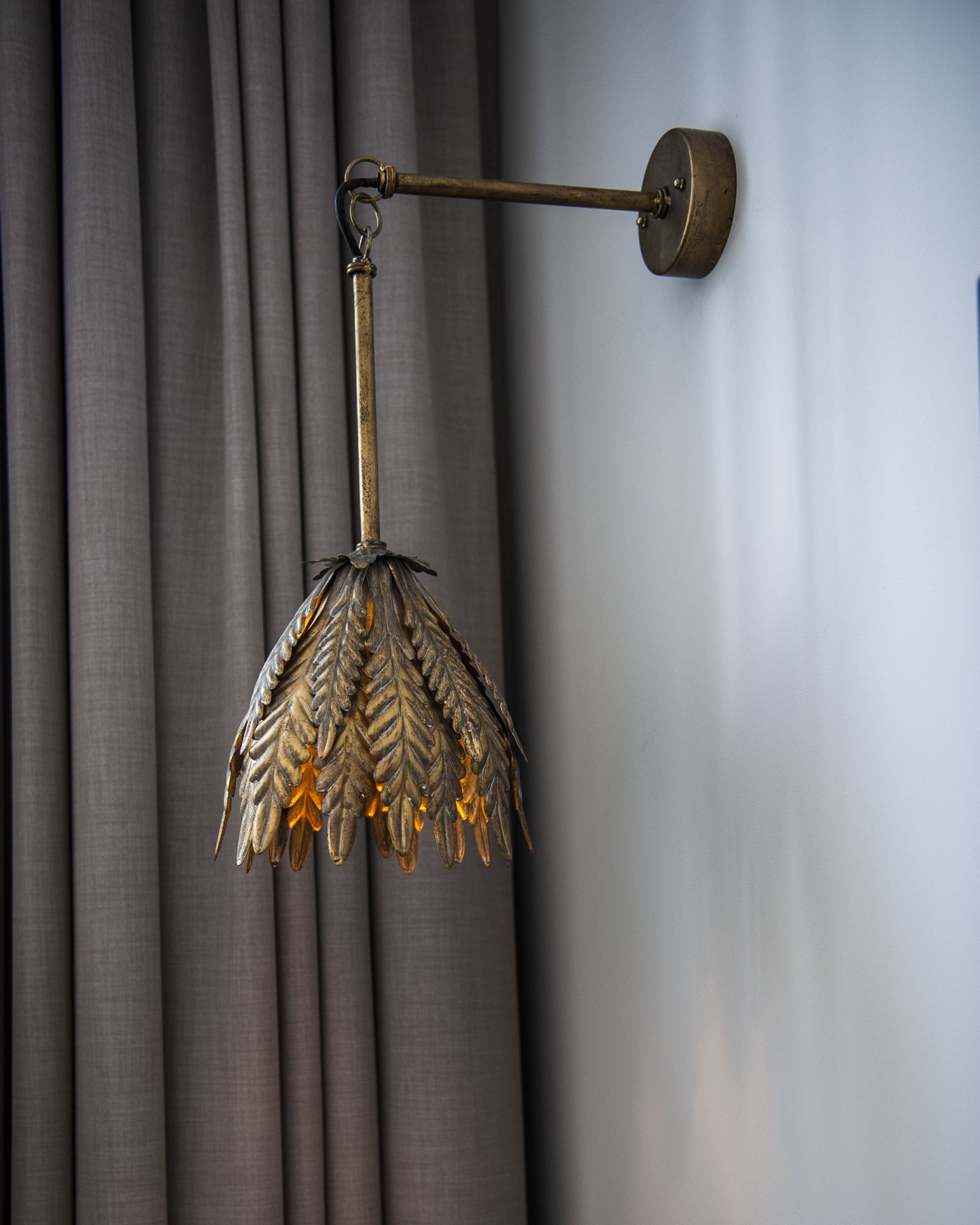 Una lámpara de pared con una pantalla en forma de hoja.