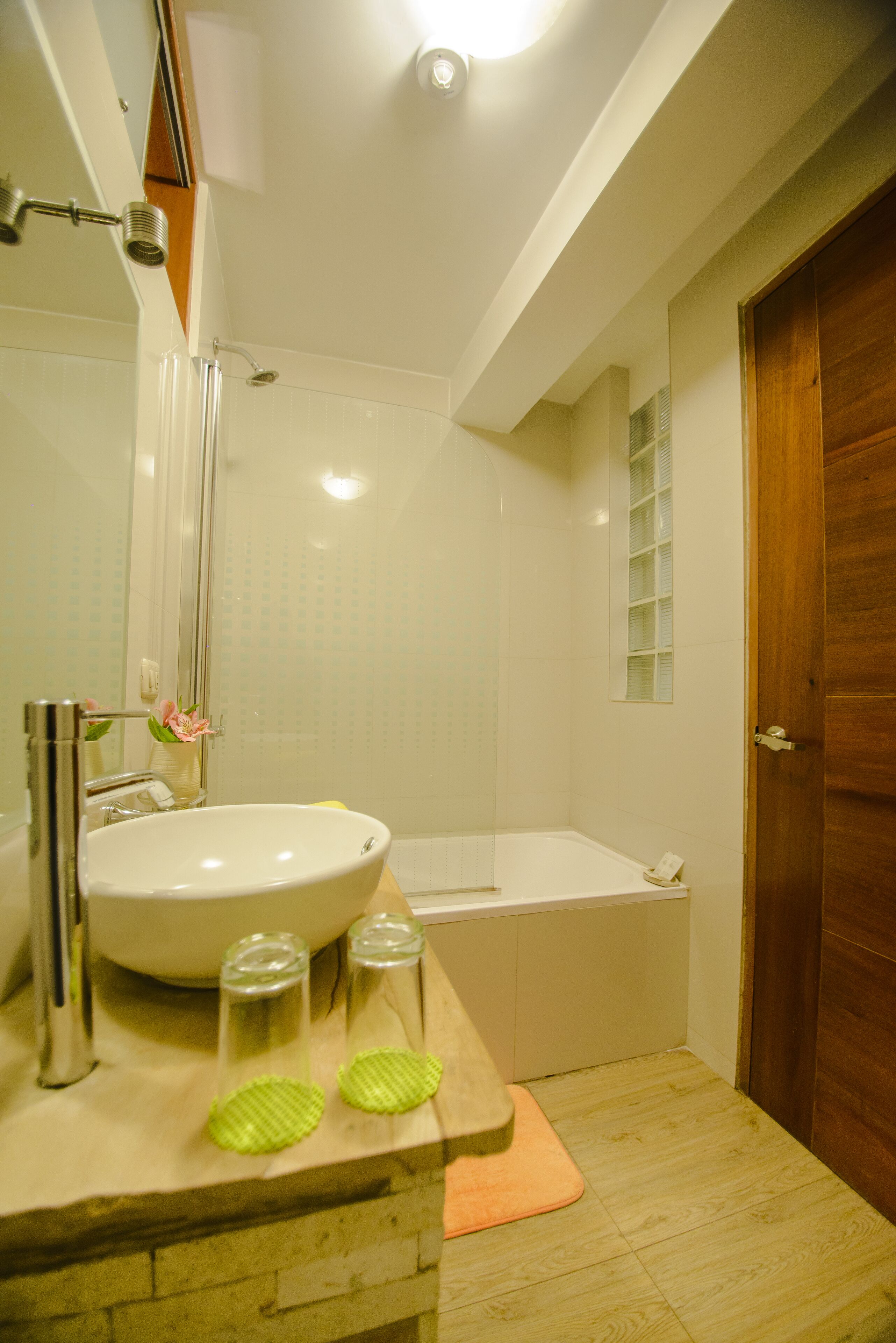 Un baño con lavabo, espejo, ducha y bañera.