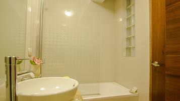 Un baño con lavabo, espejo, ducha y bañera.