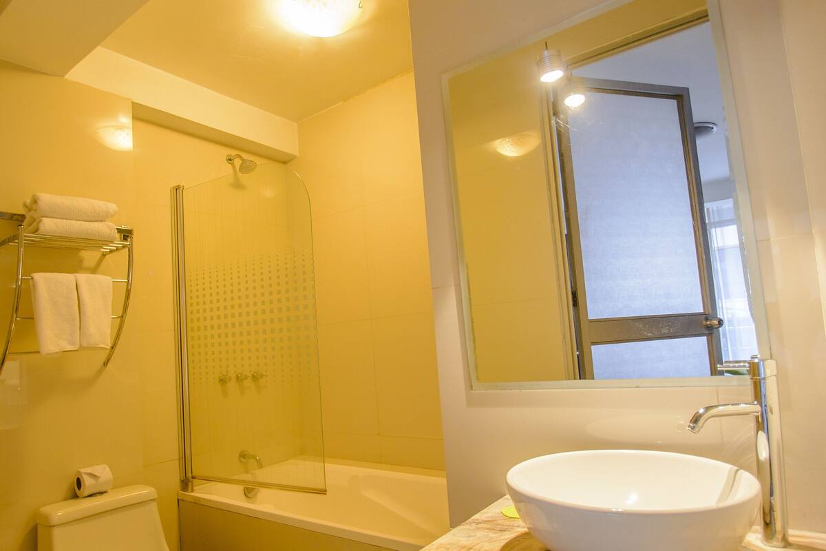 deluxe quadruple room | bathroom | combined shower/bathtub, hair dryer, towels, soap