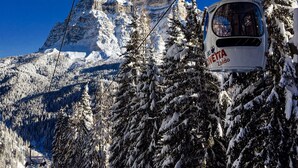 A cable car with 'SVITTA' and 'Zoldo' visible, moving through a snowy forest with a mountain in the background. - Casa Piva 1 (Val di Zoldo)