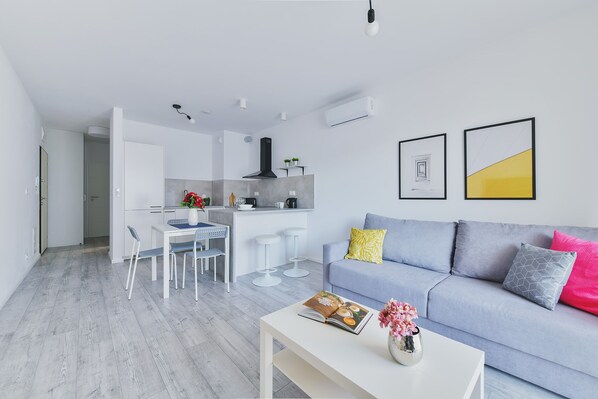 A modern apartment with a kitchen, dining area, and living room.