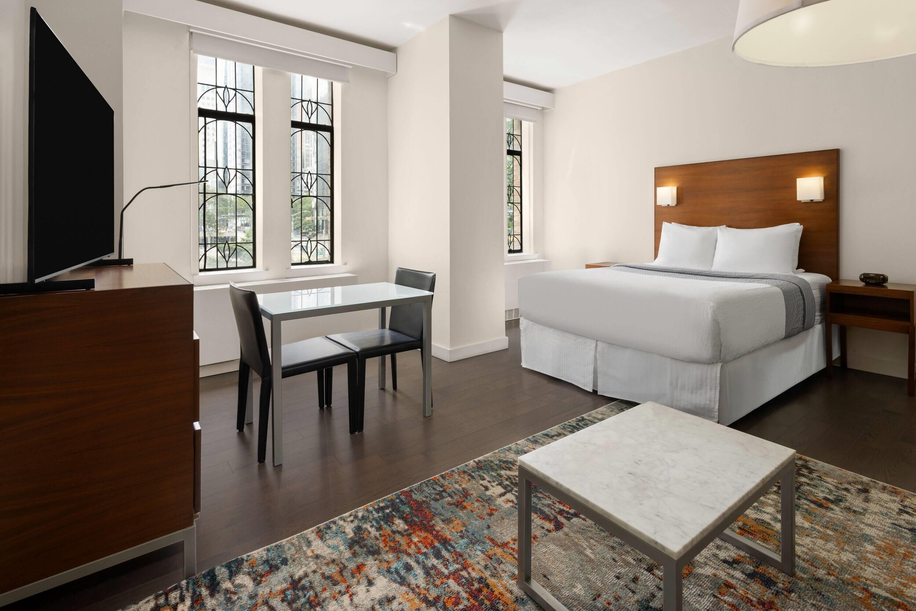 Une chambre d’hôtel moderne équipée d’un grand lit, d’un bureau, d’une chaise et d’une télévision.