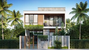 Een moderne villa met een tweetal verdiepingen, grote ramen en een balkon.