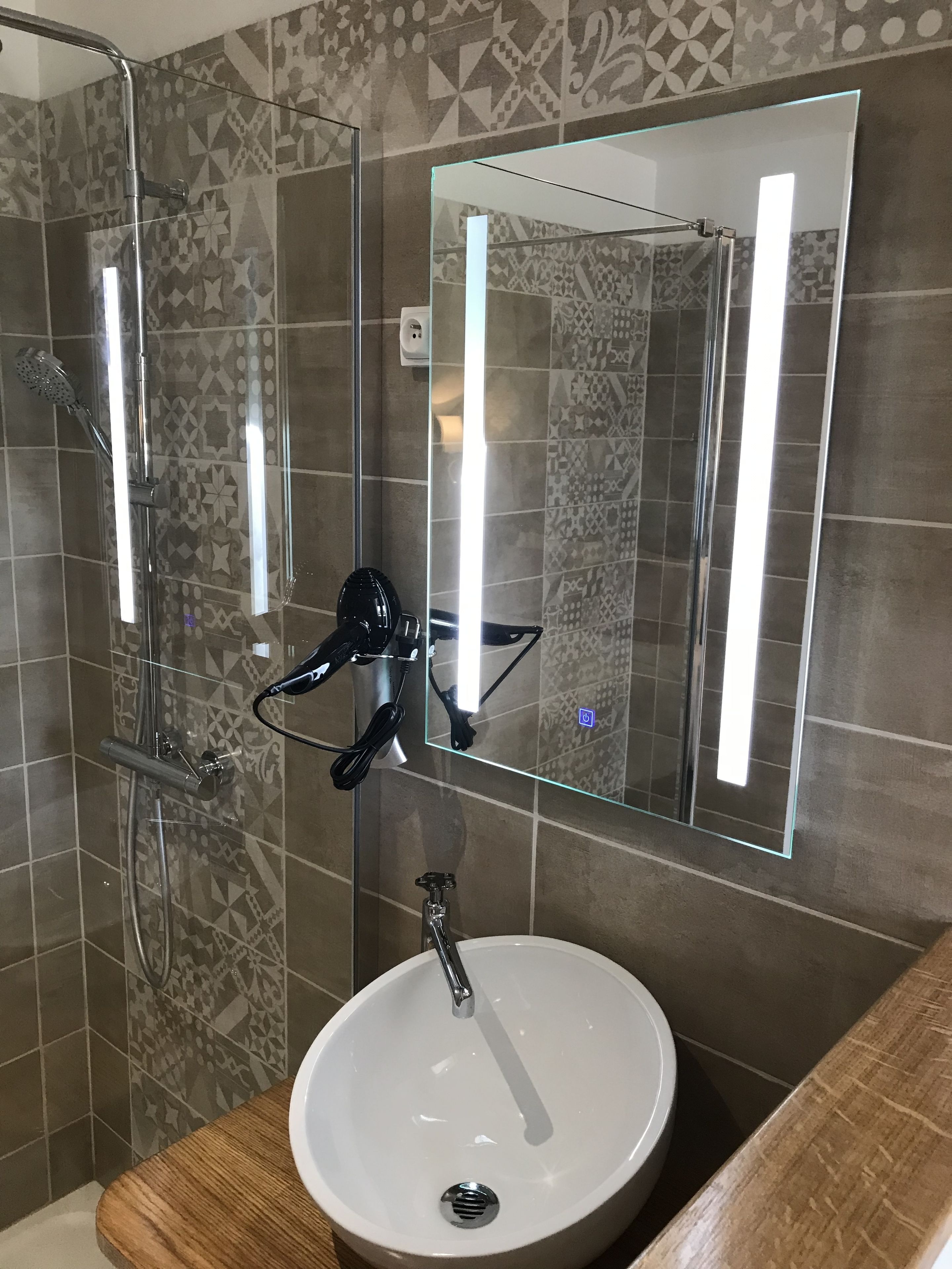 A bathroom with a shower, a sink, and a mirror.