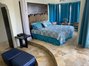 Une chambre à coucher avec un lit, une petite table, une chaise et un banc.