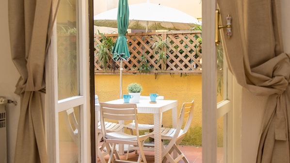 An outdoor patio with a white table, two blue cups, and a potted plant. - Rental In Rome Panieri Terrace Apartment (Rome)