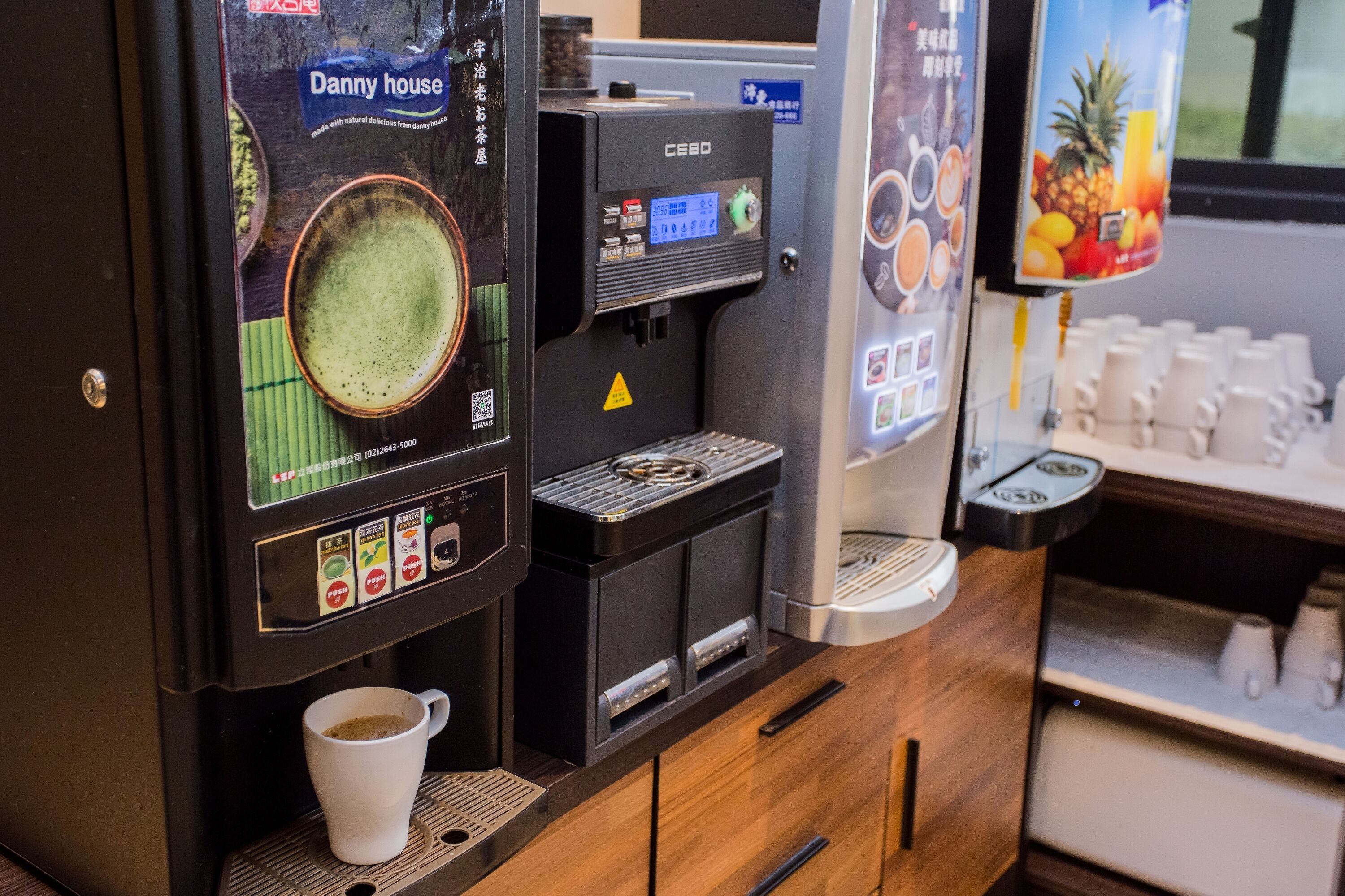 A coffee machine with a cup of coffee, a beverage dispenser, and a menu display.
