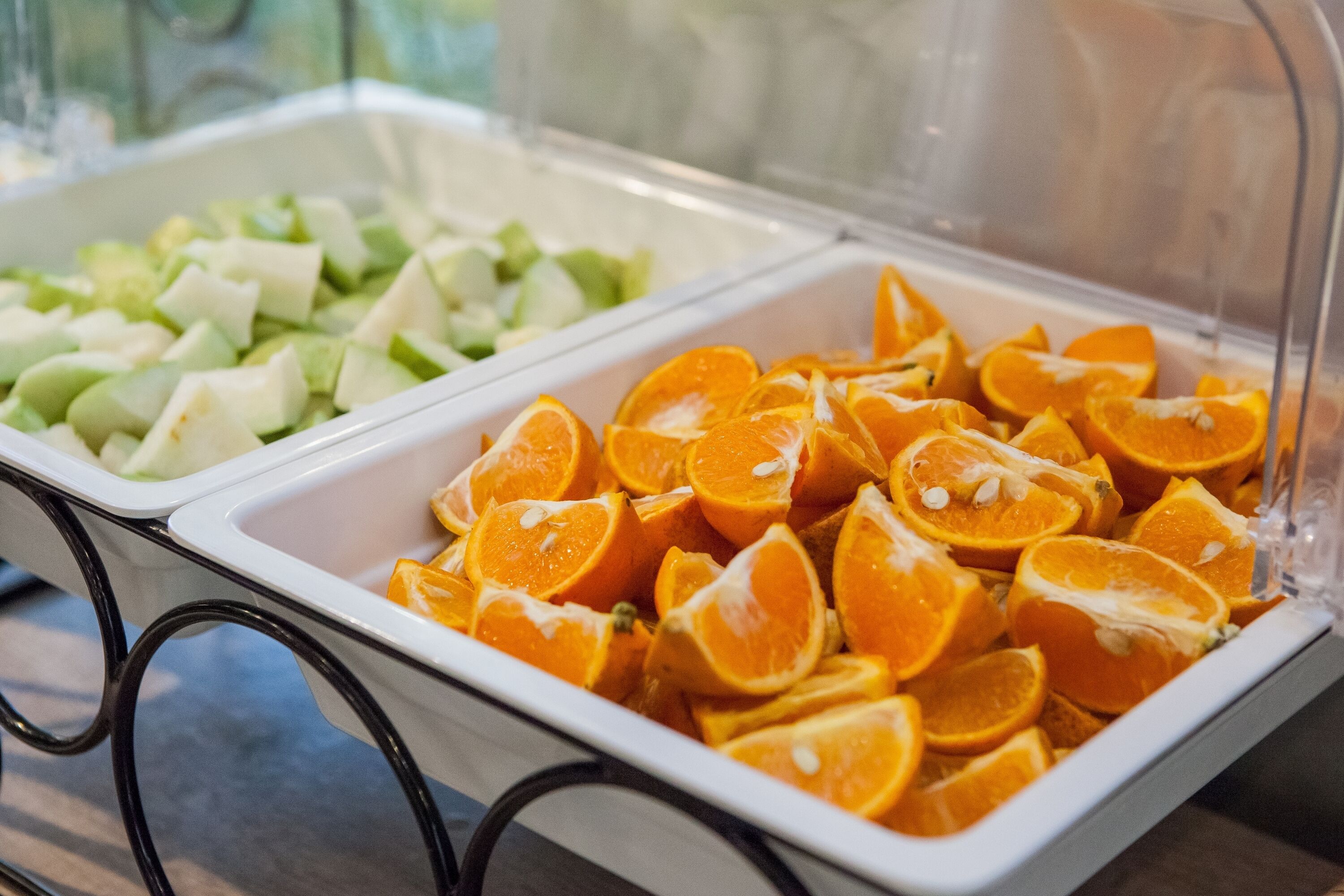 Ein Buffet mit drei Bereichen: eine Stelle mit Apfelscheiben, eine mit Orangenscheiben und eine mit Gurkenscheiben.