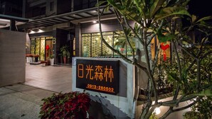 A hotel entrance with a sign displaying the name and contact number. - SunLight Forest (Taitung)