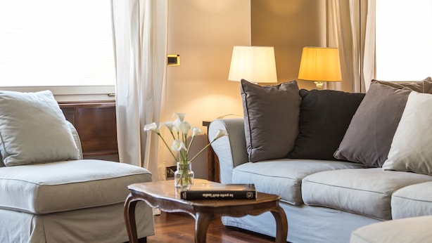 Un salon moderne avec deux canapés, une table basse et une lampe.