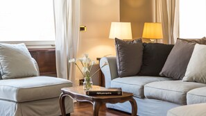 Ein modernes Wohnzimmer mit zwei Sofas, einem Couchtisch und einer Lampe.