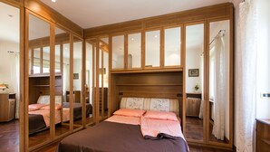 Une chambre à coucher avec un grand lit, une armoire en bois et un meuble avec une porte-miroir.