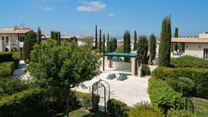 Ein Innenhof mit Pool, Liegestühlen und einer Pergola.