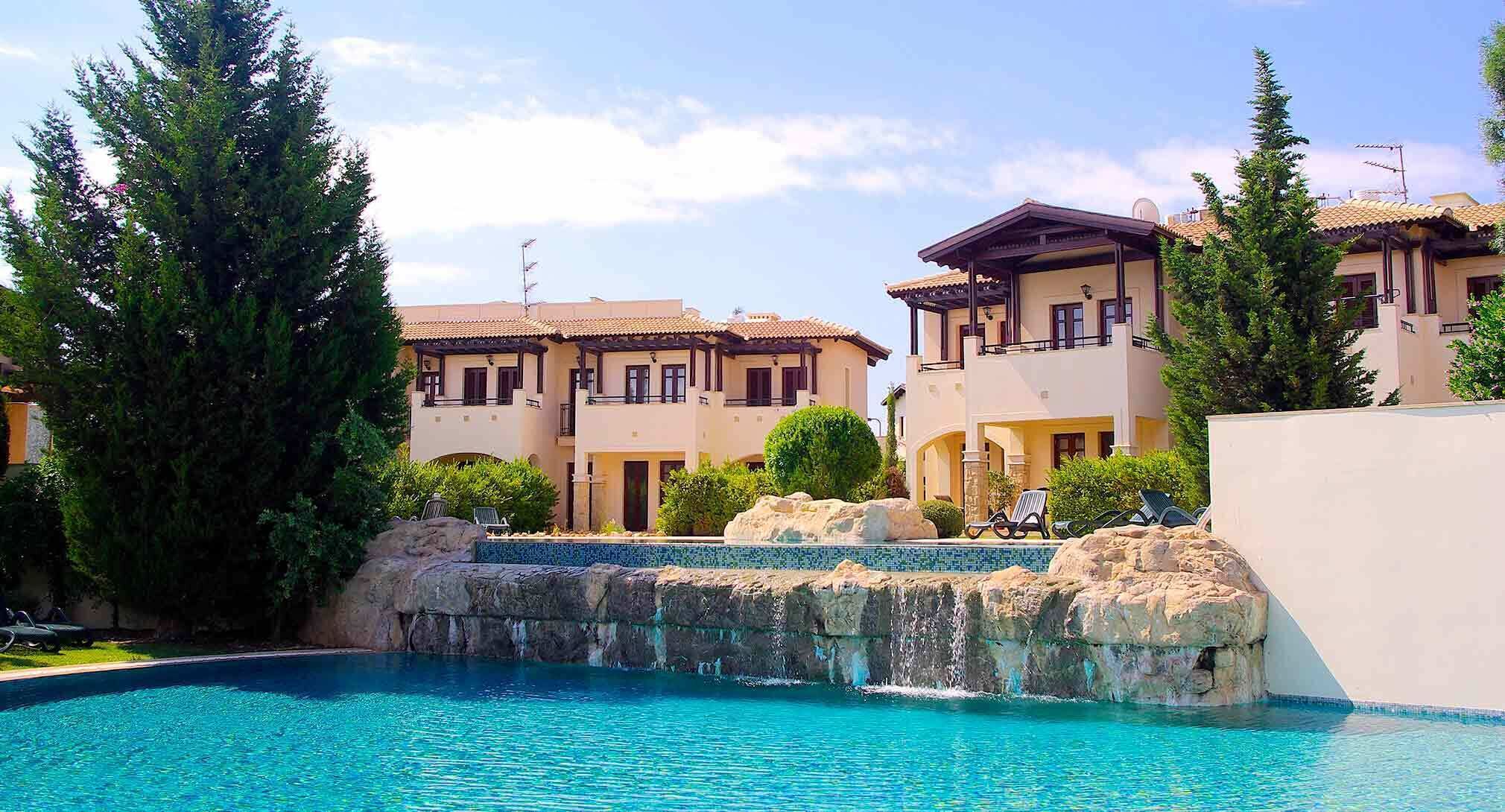 Um resort com piscina, edifícios de vários andares e paisagem rochosa.