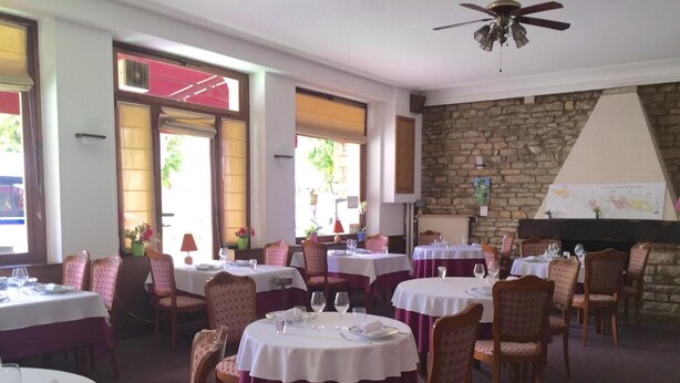 A restaurant with round tables covered in white tablecloths and chairs with a polka dot pattern. - Hotel le Vendangerot (Rully)