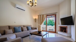 Uma sala de estar moderna com sofá, poltronas, mesa de centro, lareira e televisão.