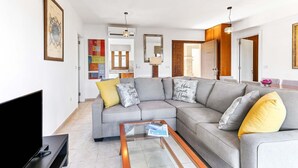 A modern living room with a grey sectional sofa, a coffee table, and a flat-screen TV. - Apartment DC01 - Kalypso (Kouklia)