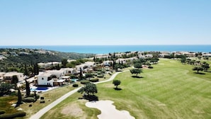 Um resort costeiro com vilas, um campo de golfe e vista clara para o mar.