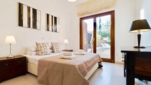 Quarto com uma cama, mesas de cabeceira e vista para o exterior.