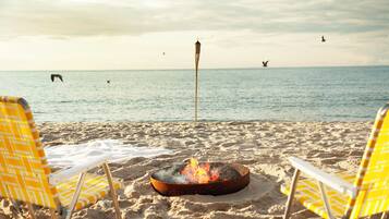 Privat strand, hvit sand, solsenger og parasoller