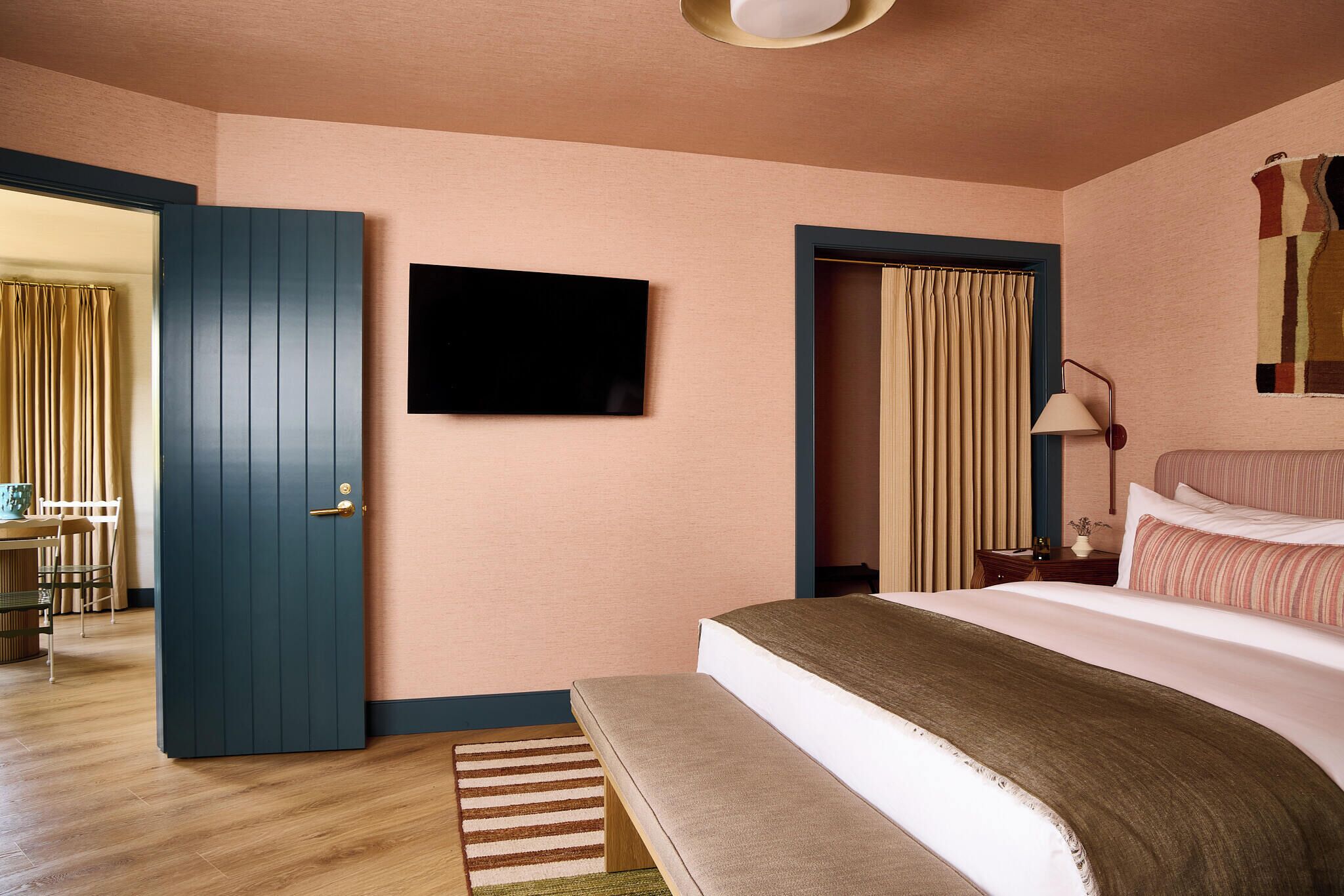 Una camera da letto con un letto, una televisione, una scrivania e una sedia.