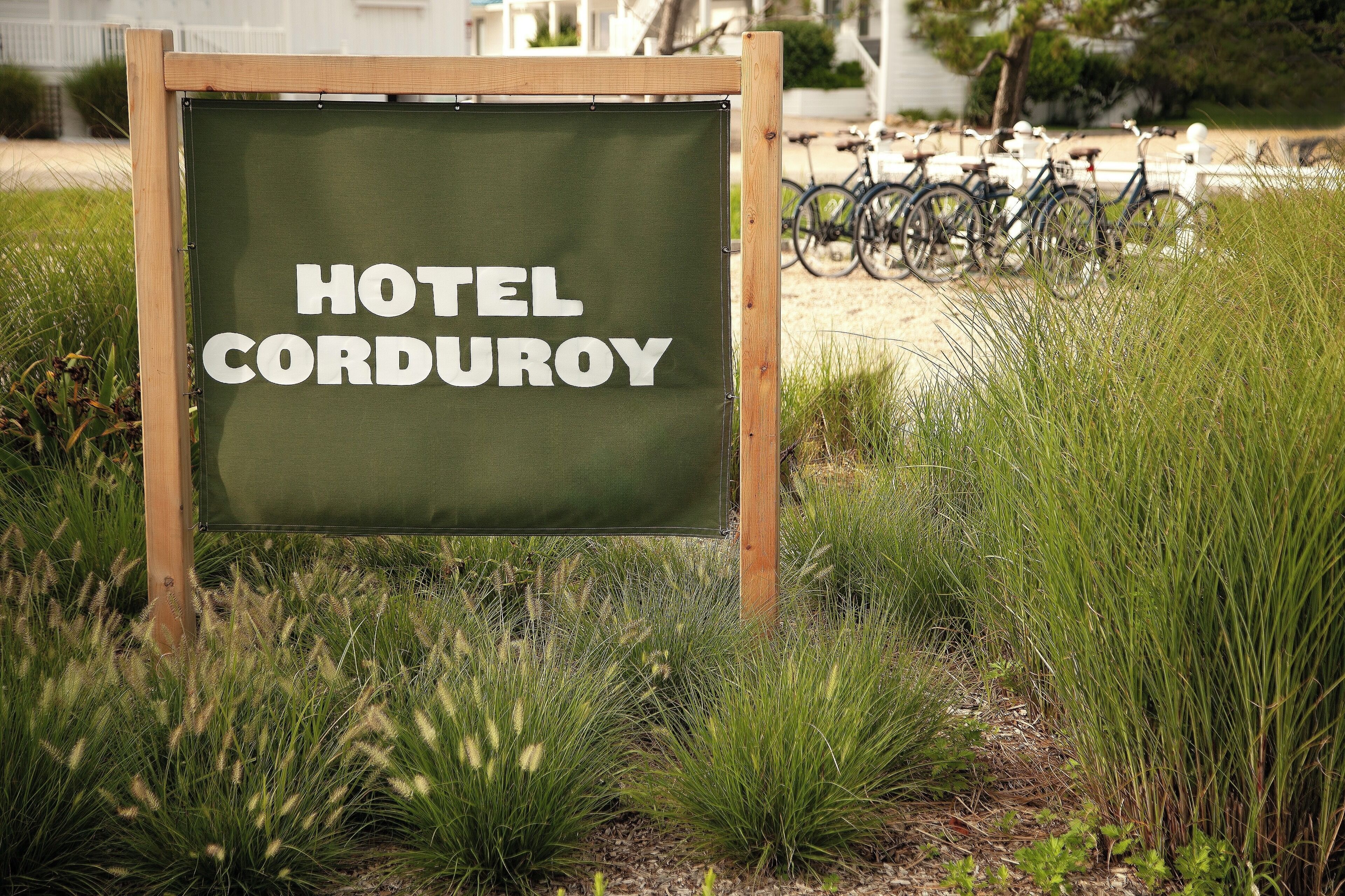 Señalización de Hotel Corduroy con marco de madera y fondo verde.