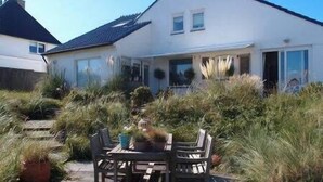 Una casa con un patio que tiene una mesa y sillas.