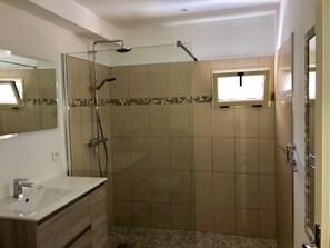 A bathroom with a shower, a sink, and a mirror. - 1 bedroom apartment in villa, quiet, sea view, near beaches and town center (Propriano)