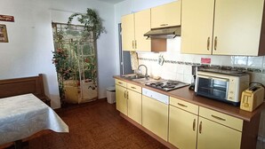A compact kitchen with yellow cabinets, a sink, a stove, and a toaster. - STUDIO L'AMIRAUTE (BORMES-LES-MIMOSAS)