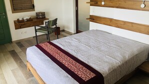 Un dormitorio con cama, escritorio y silla.