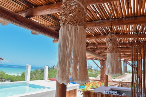 A beachside pool area with a wooden ceiling and hanging macramé decorations. - Soho Boutique Holbox - Adults Only (Isla Holbox)