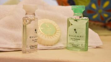 Dos botellas de Eau de Parfum BVLGARI y una barra de jabón sobre una toalla blanca.