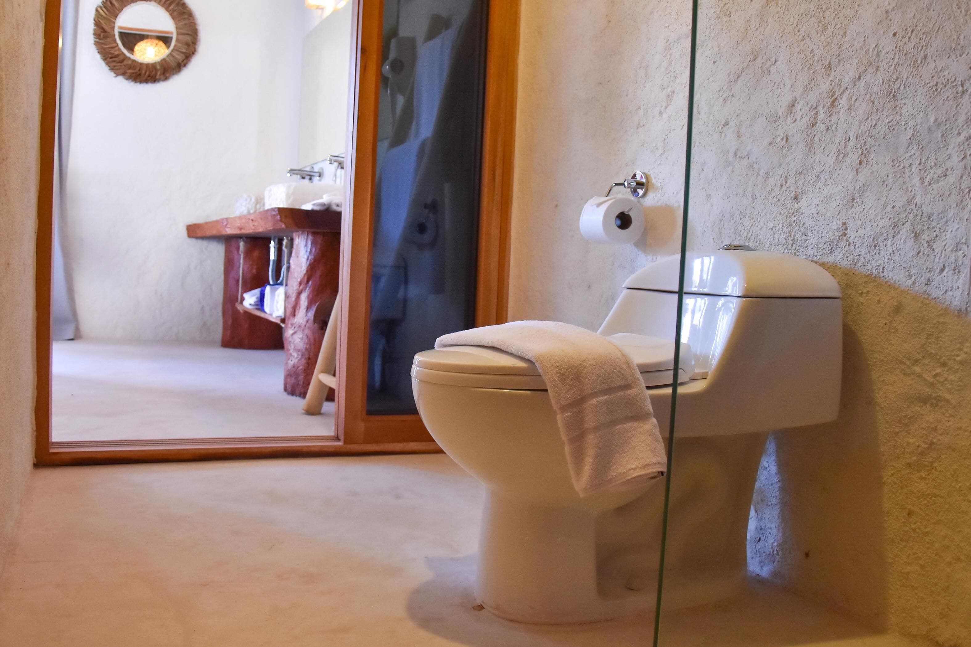 A bathroom with a toilet, a sink, and a mirror.