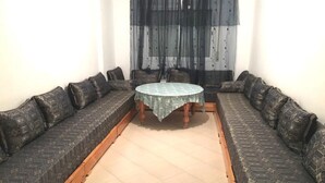 A room with a round table surrounded by two patterned sofas. - Residence Chems Corniche Martil 3917 (Martil)