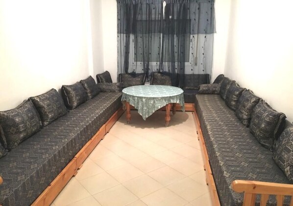 A room with a round table surrounded by two patterned sofas.