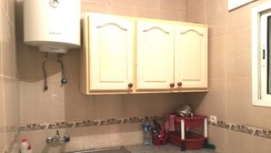 A kitchen with a built-in gas stove, a sink, and a water heater. - Residence Chems Corniche Martil 3917 (Martil)