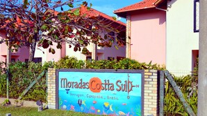 Une enseigne pour « Moradas Costa Sul », avec un thème sous-marin, indiquant un complexe hôtelier situé sur une plage au Brésil.
