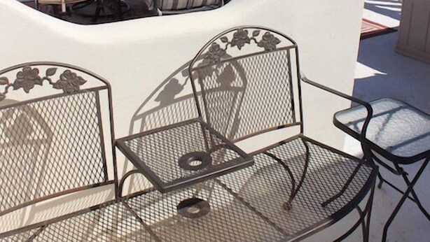 A covered outdoor seating area with a view of the sea.