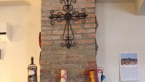 A stone fireplace with a metal grate and decorative red vines.