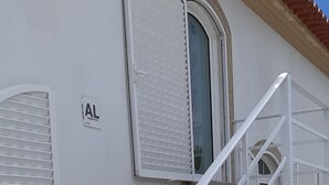 Eine Treppe mit weißen Geländern führt zu einer Tür mit einem Fenster darüber.